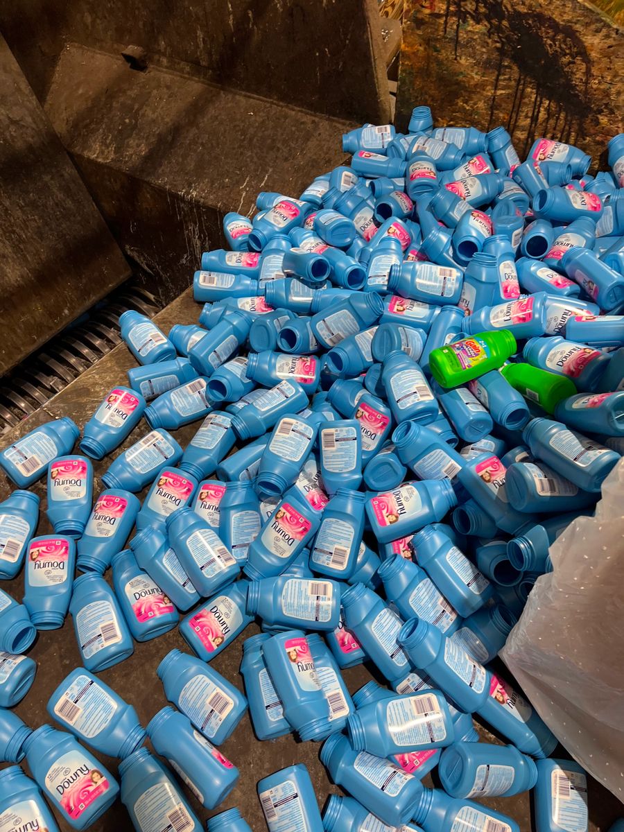 A stack of bottles flowing into a grinder