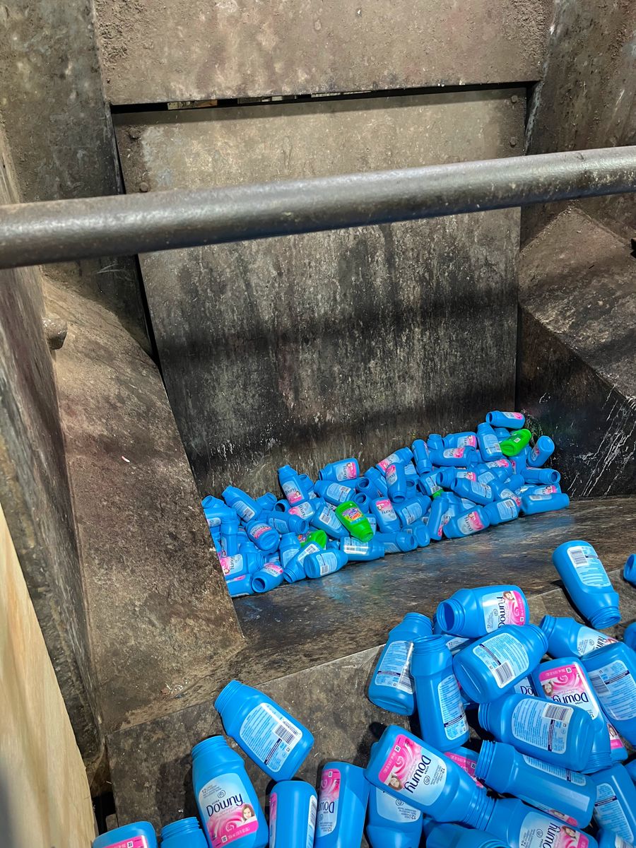 A stack of bottles flowing into a grinder